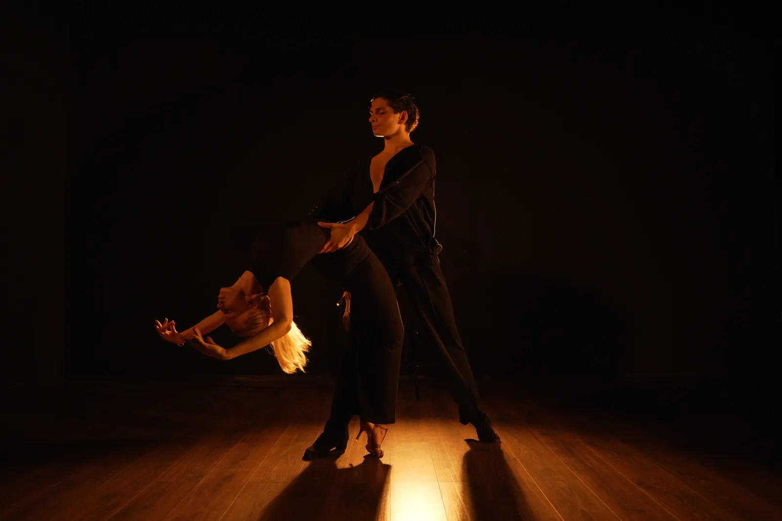 Тренер и ученица танцуют латину в паре в зале ORO Dance Studio